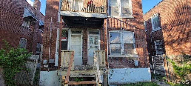 5144 Palm St, Saint Louis, MO 63115 - entrance to property featuring brick siding, a balcony, fence, and a gate
