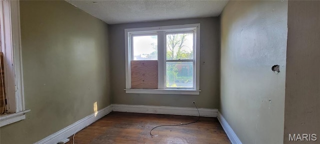 5144 Palm St, Saint Louis, MO 63115 - unfurnished room featuring wood finished floors, baseboards, and a textured ceiling