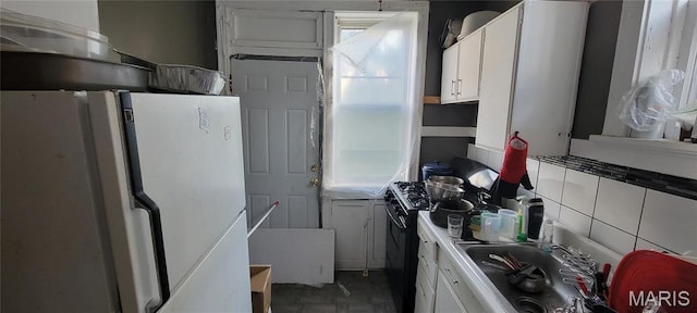 5144 Palm St, Saint Louis, MO 63115 - kitchen with freestanding refrigerator, black range with gas cooktop, healthy amount of natural light, and white cabinets