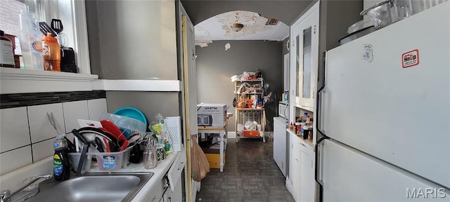 5144 Palm St, Saint Louis, MO 63115 - kitchen featuring freestanding refrigerator, a sink, and white cabinets
