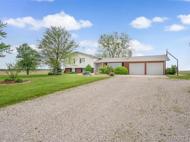 10804 Campbell Rd, Coulterville, IL 62237 - split level home featuring an attached garage, gravel driveway, brick siding, and a front yard
