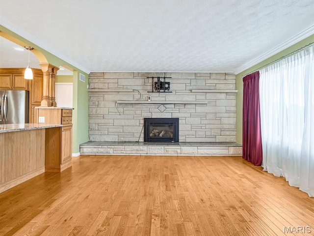 10804 Campbell Rd, Coulterville, IL 62237 - unfurnished living room with a stone fireplace, light wood-type flooring, ornamental molding, and ornate columns