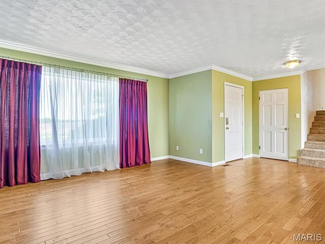 10804 Campbell Rd, Coulterville, IL 62237 - empty room featuring stairs, wood finished floors, baseboards, and crown molding
