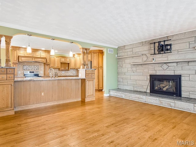 10804 Campbell Rd, Coulterville, IL 62237 - unfurnished living room with light wood-style floors, a fireplace, crown molding, and decorative columns