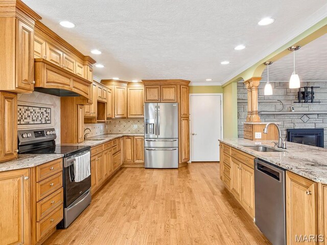 10804 Campbell Rd, Coulterville, IL 62237 - kitchen with stainless steel appliances, a sink, ornate columns, light wood-style flooring, and light stone countertops