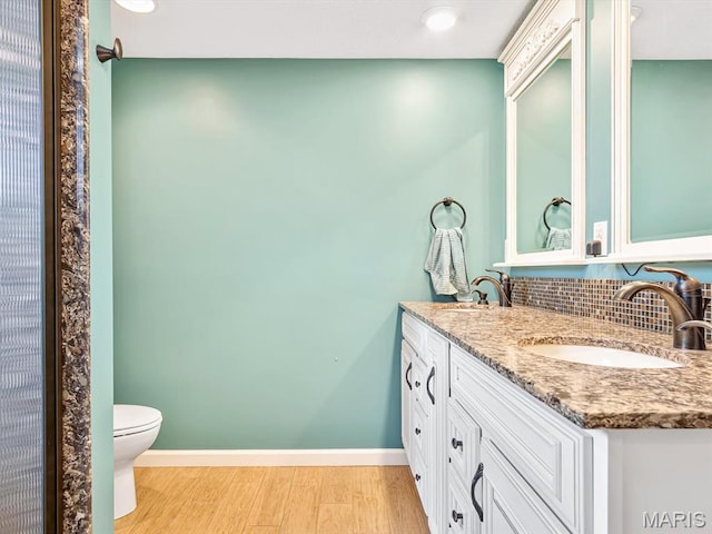 10804 Campbell Rd, Coulterville, IL 62237 - bathroom with wood finished floors, decorative backsplash, double vanity, toilet, and baseboards