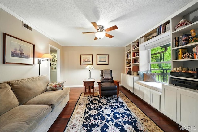 sitting room with crown molding, a ceiling fan, dark wood-style flooring, a textured ceiling, and baseboards