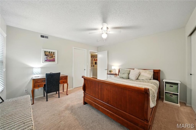 bedroom featuring light colored carpet, ceiling fan, and a textured ceiling