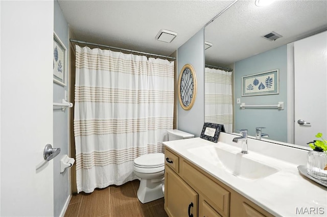 full bathroom featuring toilet, vanity, a textured ceiling, and a shower with curtain