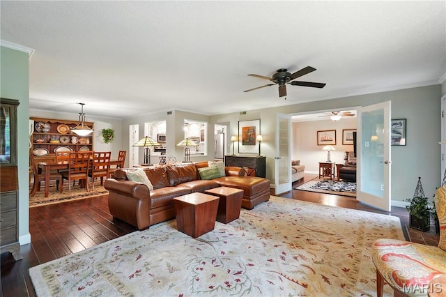 living room with ceiling fan, crown molding, dark wood finished floors, and baseboards