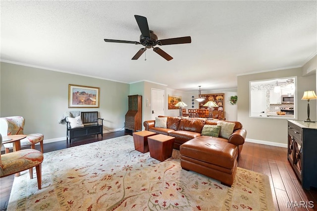 living area with dark wood-style floors, ceiling fan, crown molding, and baseboards