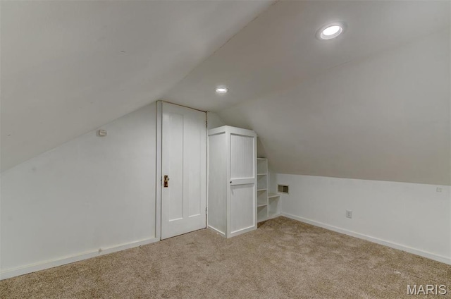 additional living space with light carpet, lofted ceiling, baseboards, and recessed lighting
