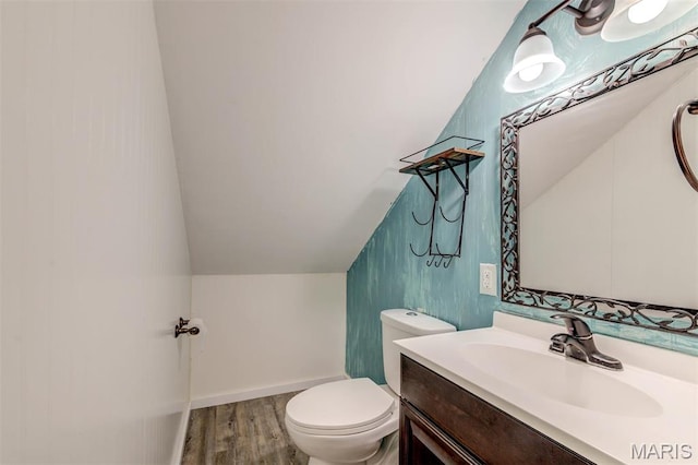 bathroom featuring vaulted ceiling, wood finished floors, vanity, and toilet