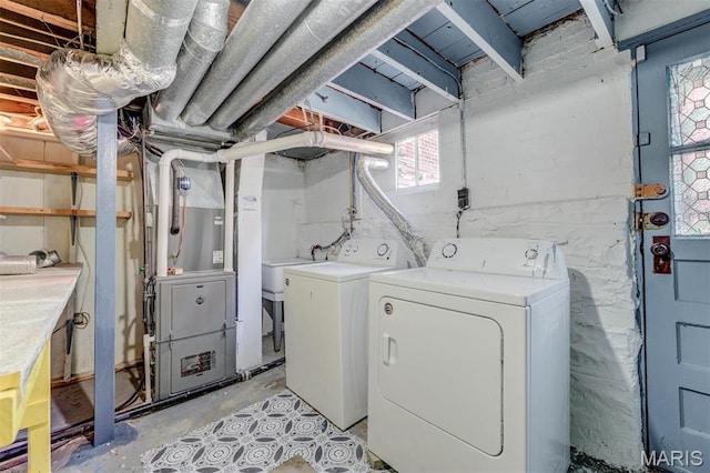 laundry area with washer and clothes dryer and heating unit
