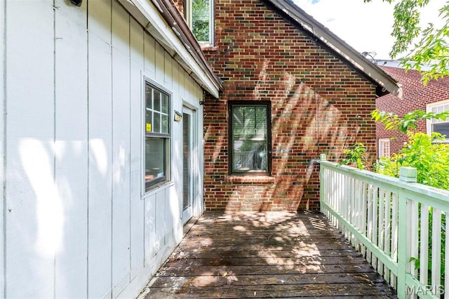 view of side of home with a deck and brick siding
