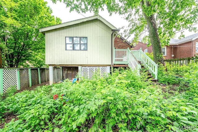 back of house featuring stairs, fence, and a wooden deck
