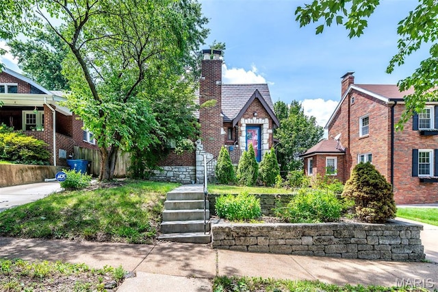 1723 Mccready Ave, Saint Louis, MO 63117 - tudor house featuring a chimney and brick siding