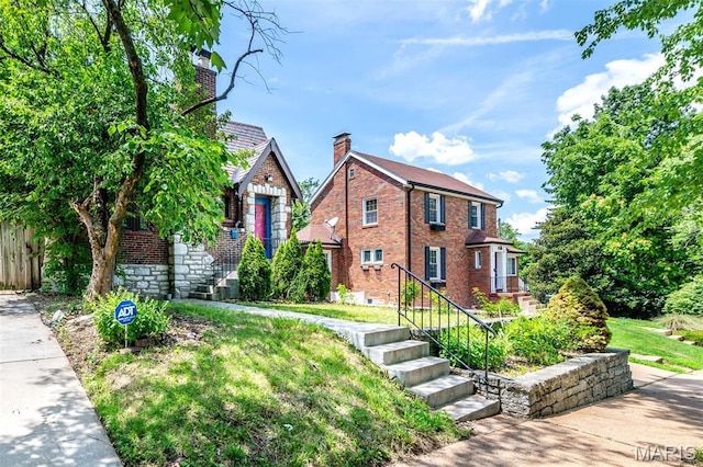 1723 Mccready Ave, Saint Louis, MO 63117 - tudor house with brick siding, a chimney, and a front yard