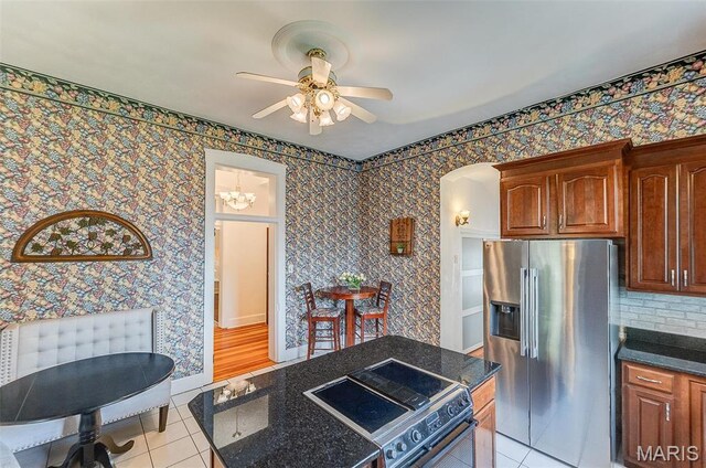 339 E Ml, Millstadt, IL 62260 - kitchen with stainless steel fridge with ice dispenser, stove, light tile patterned floors, ceiling fan, and arched walkways