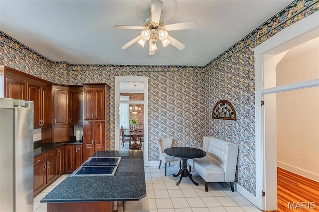 339 E Ml, Millstadt, IL 62260 - kitchen featuring freestanding refrigerator, black electric cooktop, a ceiling fan, a kitchen island, and wallpapered walls