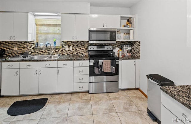 kitchen featuring stainless steel appliances, a sink, dark countertops, decorative backsplash, and white cabinets