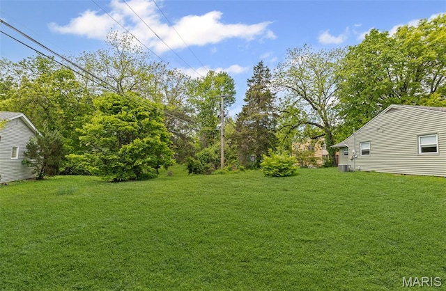 view of green lawn featuring central air condition unit