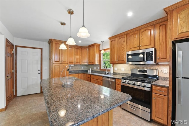 124 Dawn Dr, Washington, MO 63090 - kitchen featuring stainless steel appliances, a sink, decorative backsplash, brown cabinets, and recessed lighting