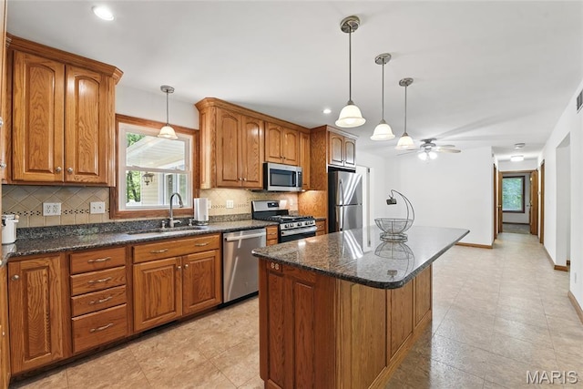 124 Dawn Dr, Washington, MO 63090 - kitchen with stainless steel appliances, a sink, plenty of natural light, brown cabinetry, and recessed lighting