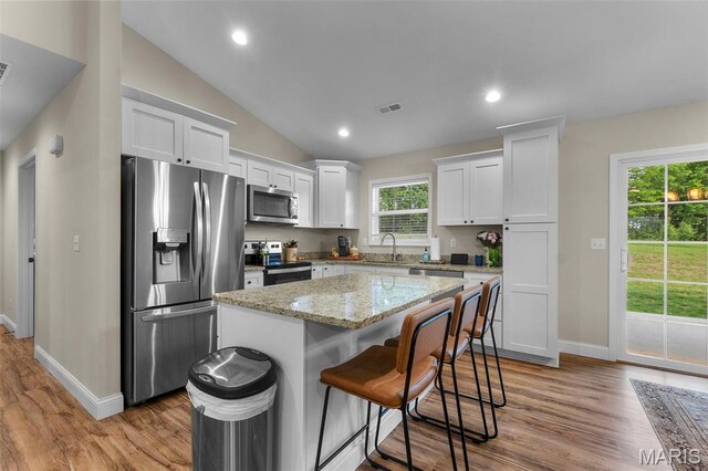1111 Tulach Ard Ct, Jackson, MO 63755 - kitchen with appliances with stainless steel finishes, white cabinetry, baseboards, a kitchen island, and light wood-style floors