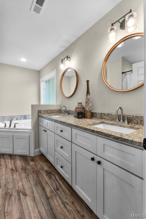 1111 Tulach Ard Ct, Jackson, MO 63755 - full bath with wood finished floors, double vanity, and a garden tub