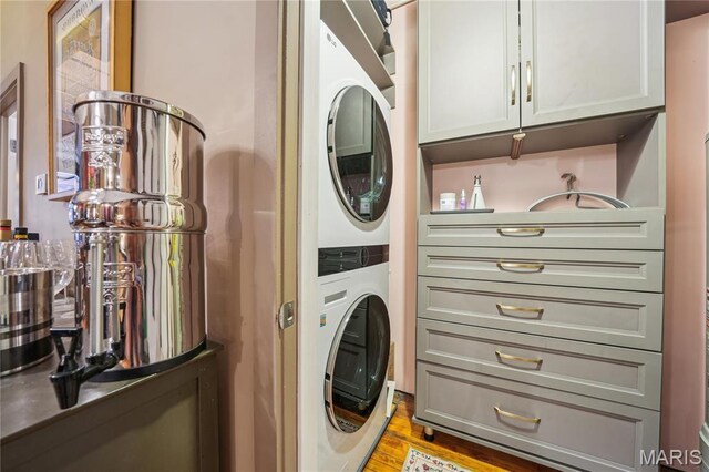 1010 Saint Charles St Unit 701, Saint Louis, MO 63101 - clothes washing area with stacked washer / dryer, light wood-style flooring, and cabinet space
