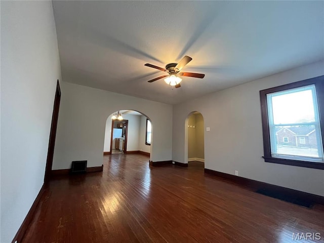 213 W Broadway, Trenton, IL 62293 - spare room with arched walkways, dark wood-style flooring, a ceiling fan, and baseboards