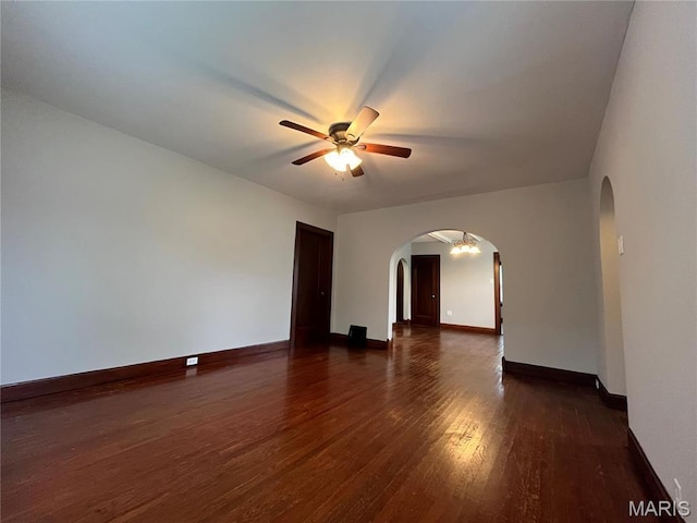 213 W Broadway, Trenton, IL 62293 - empty room featuring arched walkways, dark wood-style flooring, ceiling fan, and baseboards