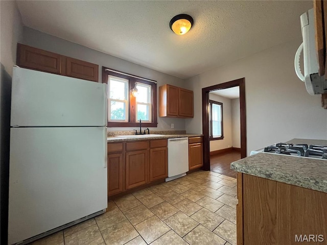 213 W Broadway, Trenton, IL 62293 - kitchen featuring white appliances, a sink, a textured ceiling, and baseboards