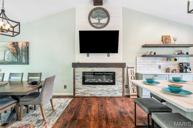159 Village Circle Dr, Lake St Louis, MO 63367 - dining space featuring dark wood-style floors, vaulted ceiling, a chandelier, and a stone fireplace