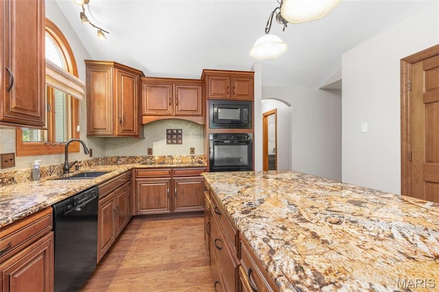 2453 Lone Trail Dr, Foristell, MO 63348 - kitchen with black appliances, a sink, vaulted ceiling, light wood-style flooring, and arched walkways