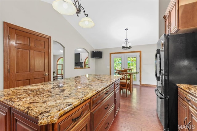 2453 Lone Trail Dr, Foristell, MO 63348 - kitchen featuring freestanding refrigerator, lofted ceiling, wood finished floors, light stone counters, and a kitchen island
