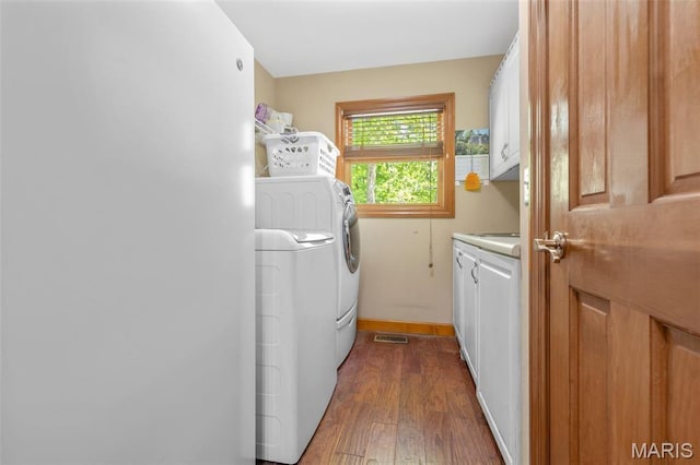 2453 Lone Trail Dr, Foristell, MO 63348 - laundry area with cabinet space, independent washer and dryer, wood finished floors, and baseboards