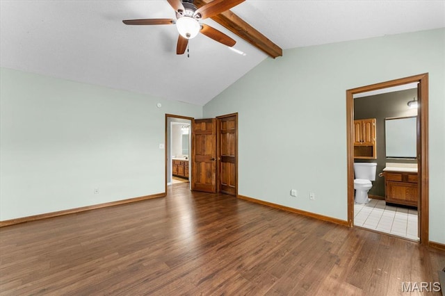 unfurnished bedroom with ensuite bathroom, wood finished floors, and baseboards