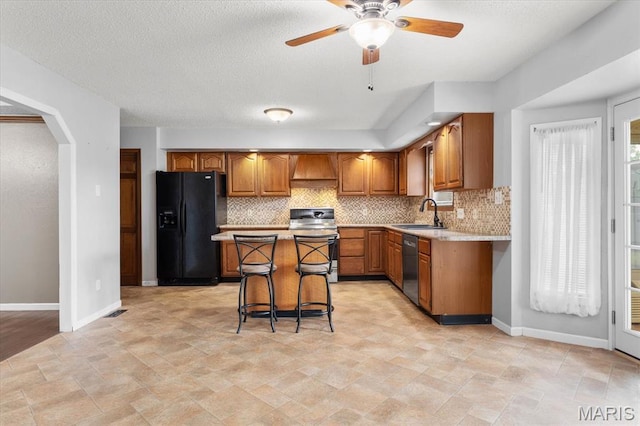 kitchen with stainless steel appliances, brown cabinets, a center island, and tasteful backsplash