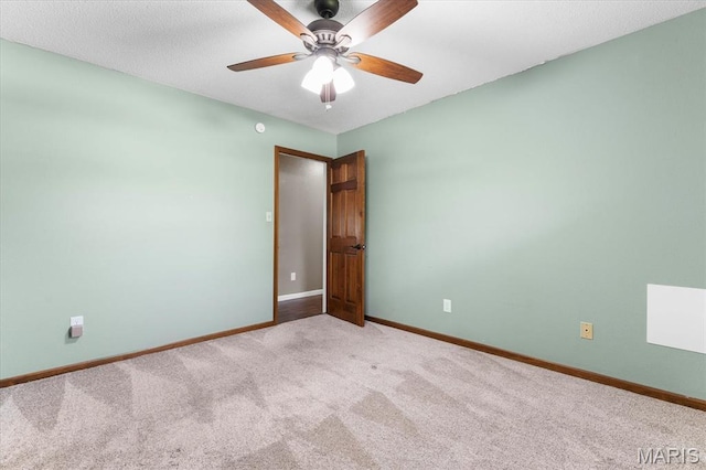 spare room featuring carpet, baseboards, and a ceiling fan