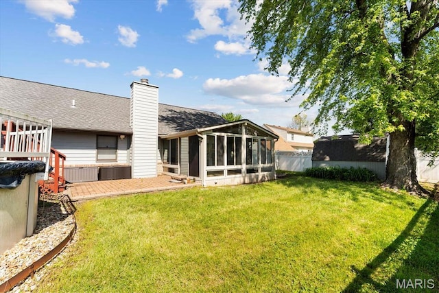 rear view of property featuring a sunroom, a shingled roof, and a chimney