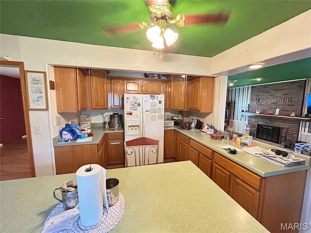 120 E Beth St, Licking, MO 65542 - kitchen with brown cabinets, light countertops, a ceiling fan, white fridge with ice dispenser, and a brick fireplace