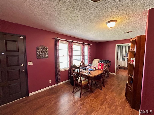 120 E Beth St, Licking, MO 65542 - dining area with wood finished floors, a textured ceiling, and baseboards