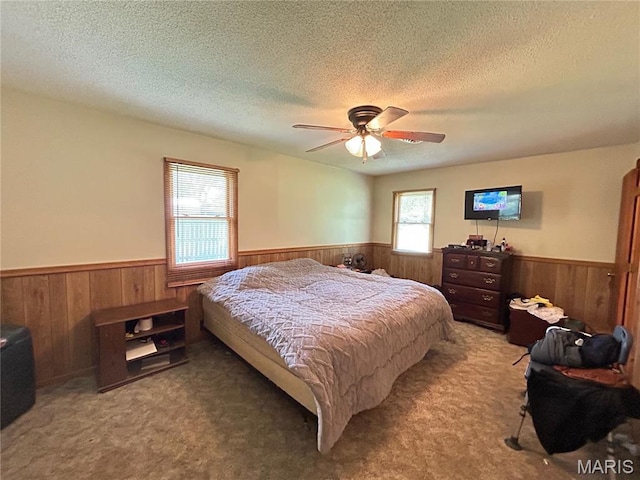 120 E Beth St, Licking, MO 65542 - carpeted bedroom featuring wainscoting, wooden walls, a textured ceiling, and ceiling fan