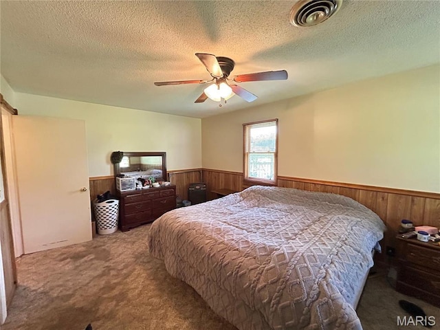 120 E Beth St, Licking, MO 65542 - bedroom with wainscoting, carpet flooring, wood walls, a textured ceiling, and a ceiling fan
