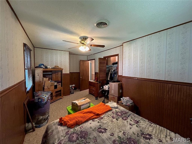 120 E Beth St, Licking, MO 65542 - bedroom with wainscoting, wallpapered walls, a textured ceiling, ceiling fan, and a spacious closet