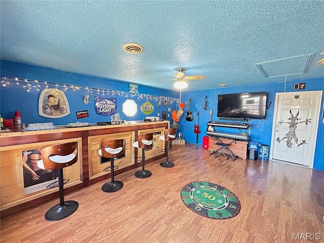 120 E Beth St, Licking, MO 65542 - rec room featuring wood finished floors, a bar, a textured ceiling, a ceiling fan, and attic access