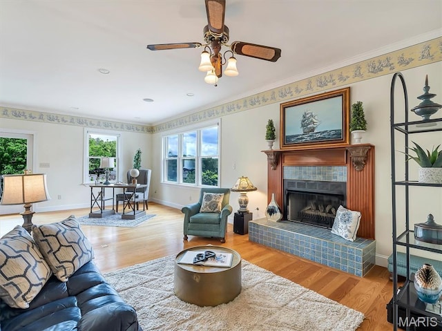 590 Fairway Dr, Union, MO 63084 - living room featuring wood finished floors, a tiled fireplace, ceiling fan, baseboards, and ornamental molding