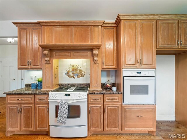 590 Fairway Dr, Union, MO 63084 - kitchen featuring white appliances, dark stone counters, brown cabinets, and tasteful backsplash